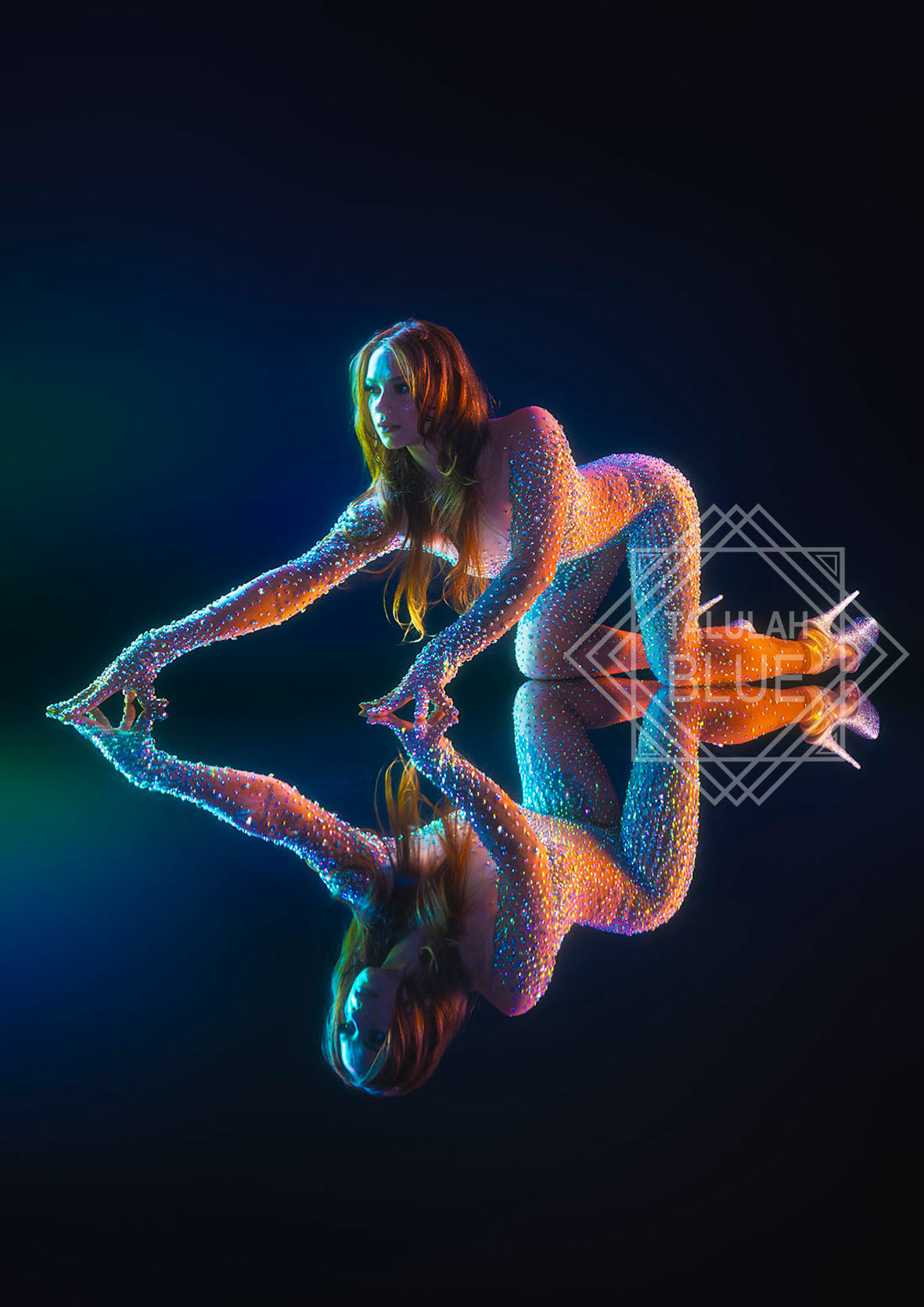 Circus costume. Person covered in glowing, multicolored dots sitting on a reflective surface with a dark background.