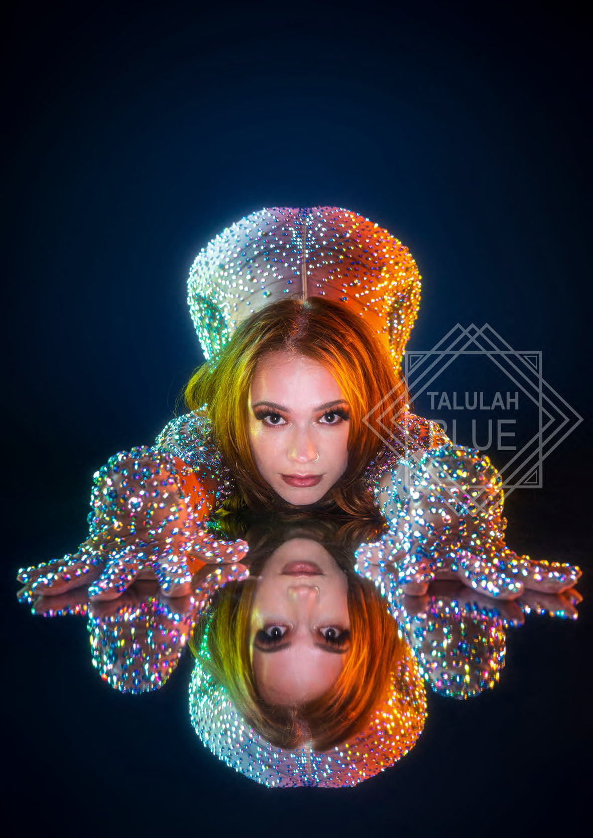 Person wearing a colorful, beaded headpiece with a dark background and 'Talulah Blue' logo.  Back view of the iridescent catsuit on a model, highlighting the fitted silhouette.