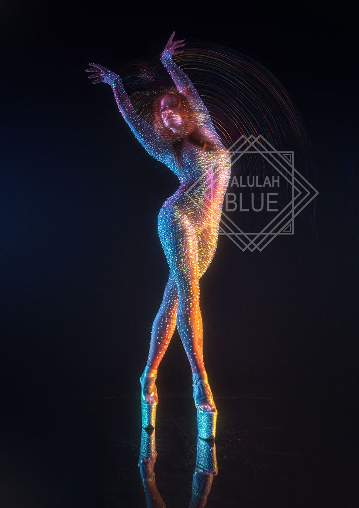 Crystal catsuit costume. Colorful light art of a person against a black background with 'Talulah Blue' logo.